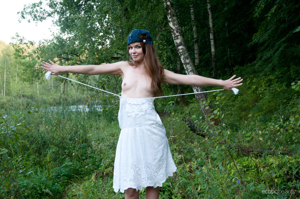 Nedda A strips in the woods as she bares her trimmed pussy.