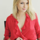 Lucy Heart smooth fair skin accentuated by a red chiffon robe