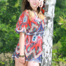 Marta E playing outside in a vibrant paisley romper