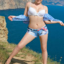 Alessandra A in her cut off denim shorts and blue checkered top playing by the water