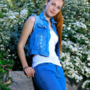 Hailey looks beautiful in a ponytail. She takes of her jeans and denim top by the flower bed.