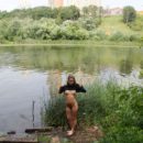 Busty girl Abbey undresses by the lake