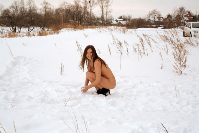 Naked Galya plays with a snow in the yard