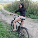 Bottomless brunette Kat on bicycle