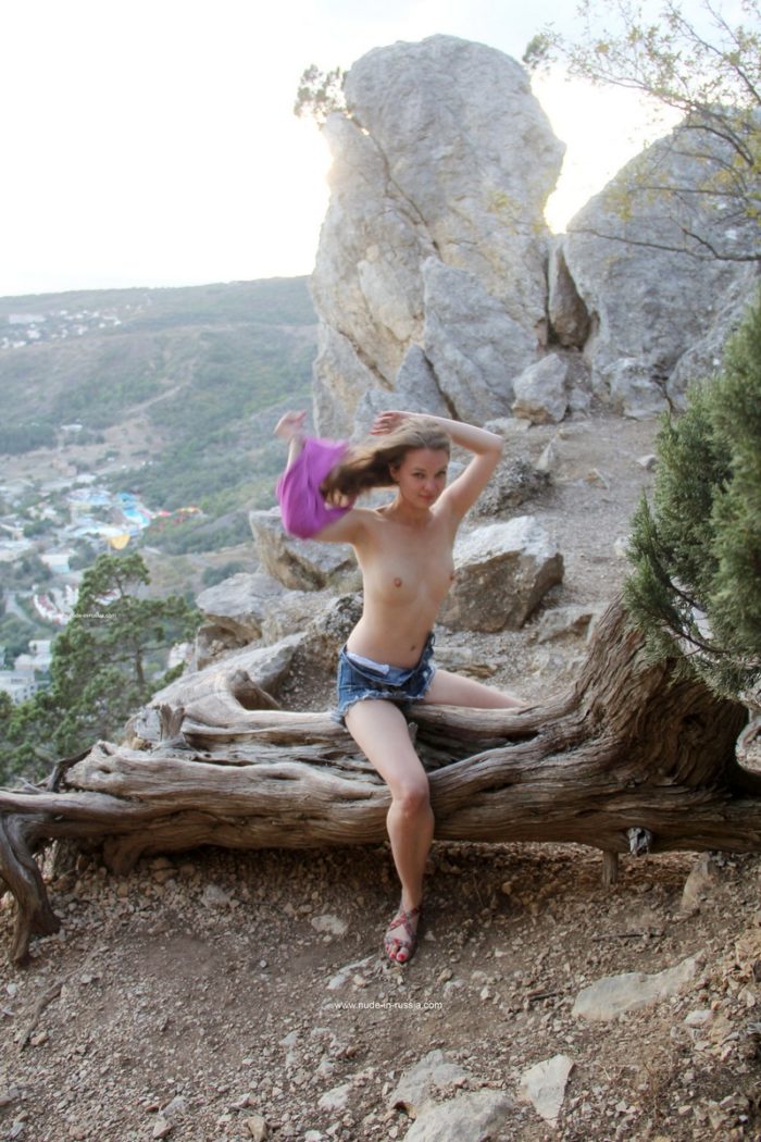 Naked blonde Anna B undresses on the rock