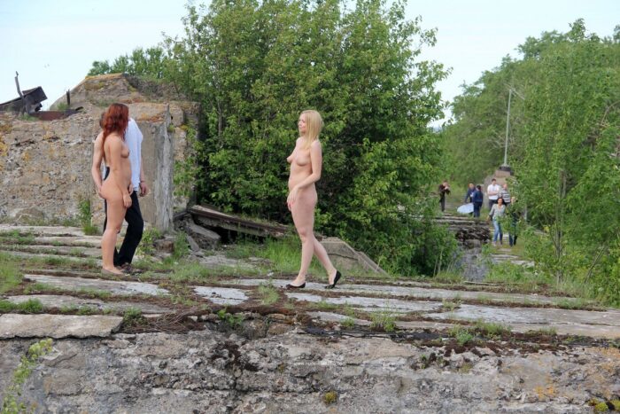 Redhead and blonde girls walks with a stranger at public place