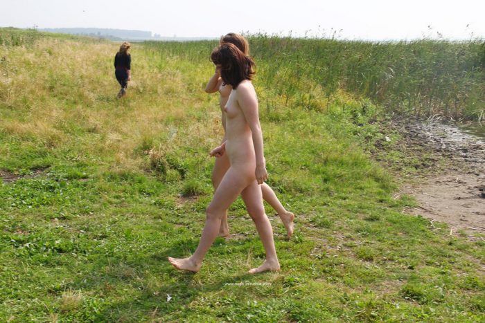 Two girls posing naked outdoors near car
