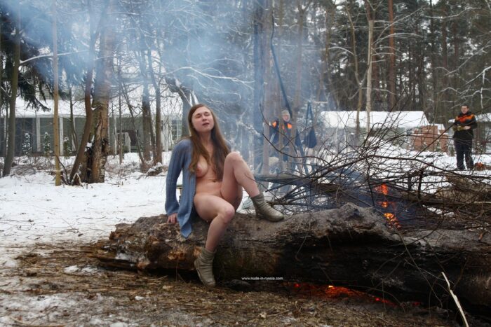 Busty teen Dana flashes her body by the winter fire