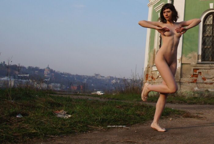 Naked Ekaterina S with sporty body near old church