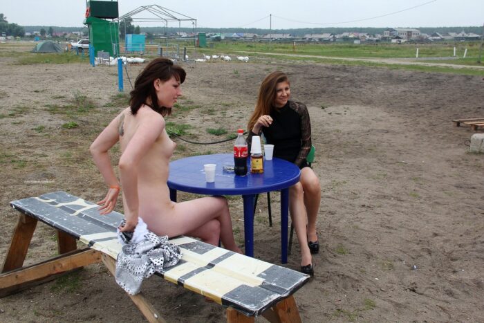 Naked girl drinks whiskey cola on the lake