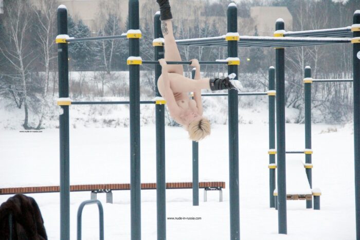 Short-haired blonde Elena B do gym outdoors at winter