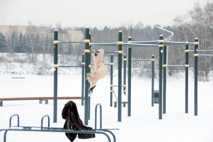 Short-haired blonde Elena B do gym outdoors at winter