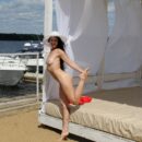 Smiling brunette Veronica Snezna loves to show her spread legs at beach cafe