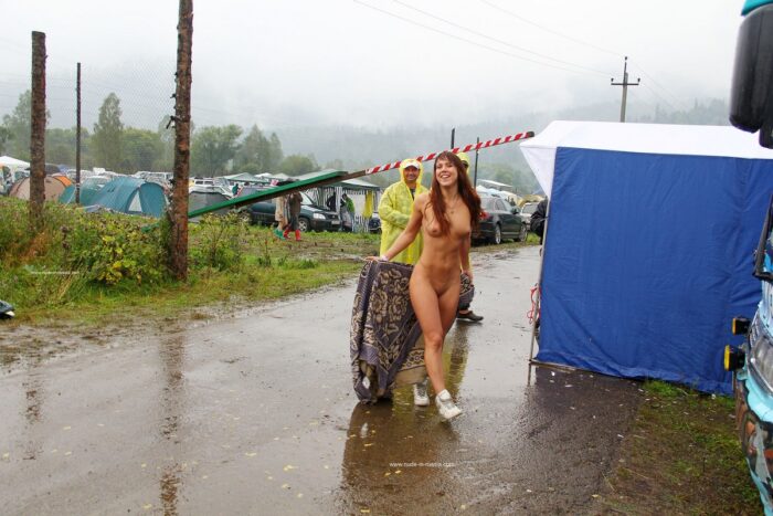 Redhead girl walks naked in front of strangers in the rain