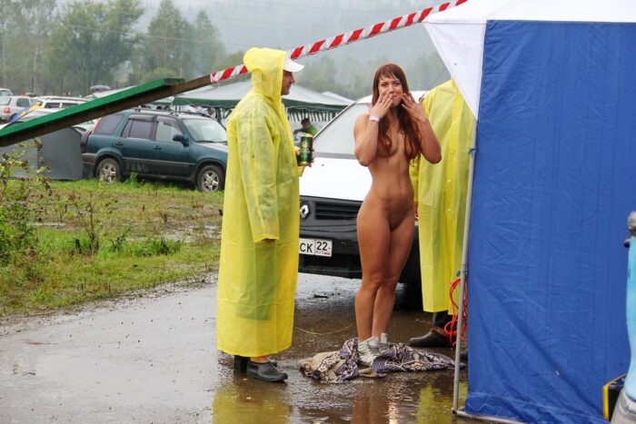 Redhead girl walks naked in front of strangers in the rain