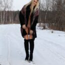 Skinny blonde plays with a snow on the road