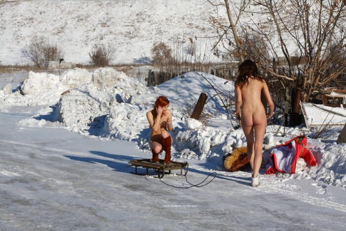 Two russian girls sledding in very cold weather