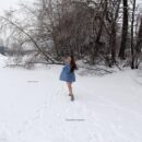 Young busty girl Dana playing with snow on a frozen lake