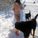 Naked brunette Klara only in bright socks posing with dogs