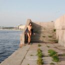 Naked tall brunette Bella on the city embankment