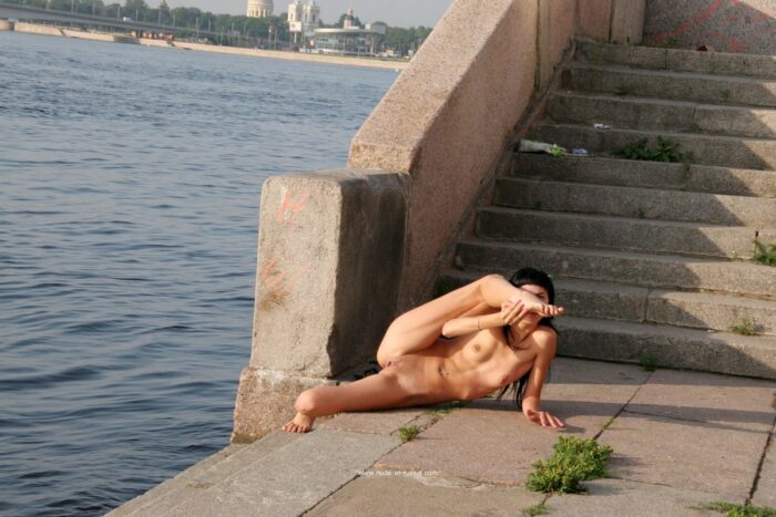 Naked tall brunette Bella on the city embankment