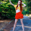 Charming red hair Sherice is taking selfies on the road spreading her long legs apart and revealing a bottomless smooth pussy underneath her red tiny skirt.