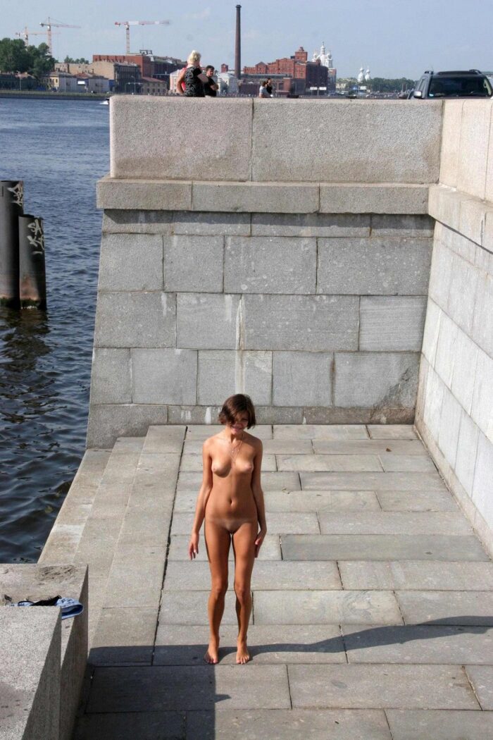 Girl Anna S undresses on the embankment in the city center
