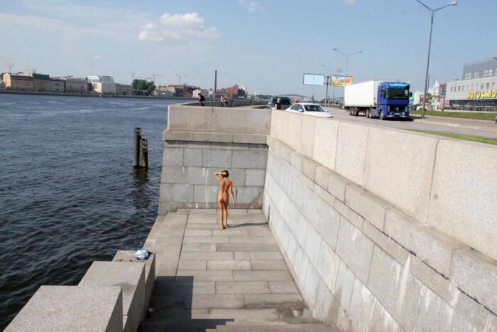 Girl Anna S undresses on the embankment in the city center