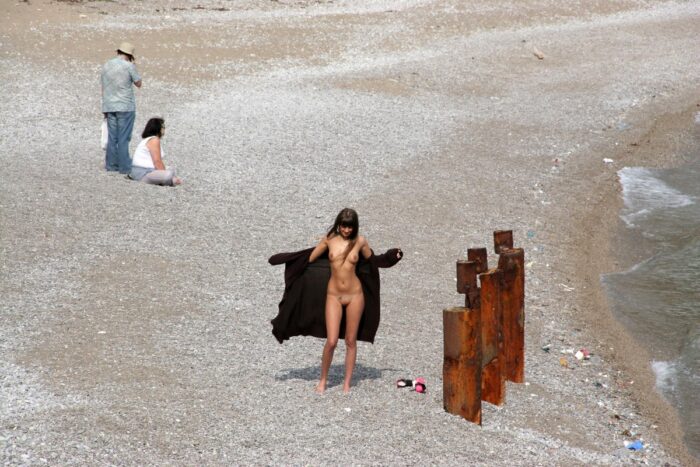 Girl Masha E in coat on the beach and promenade