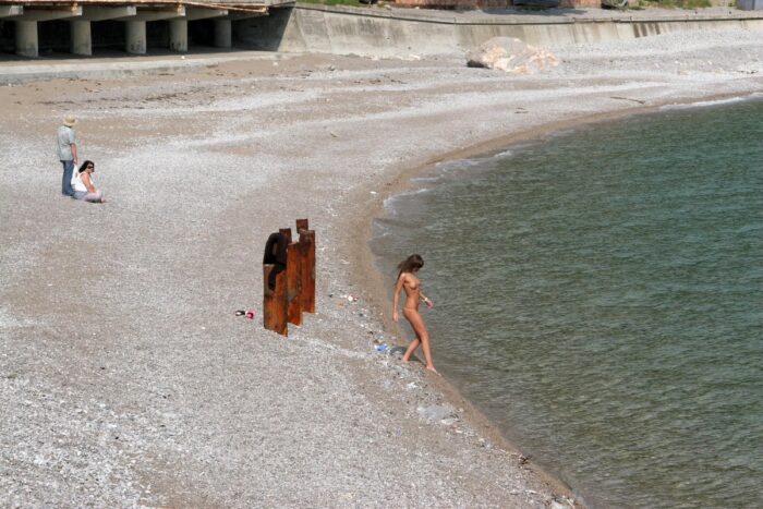 Girl Masha E in coat on the beach and promenade