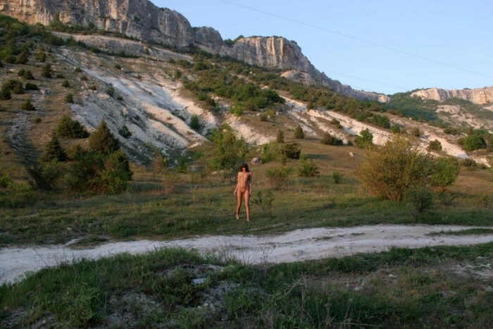 Smiling teen Masha E touches her pussy at road in the mountains