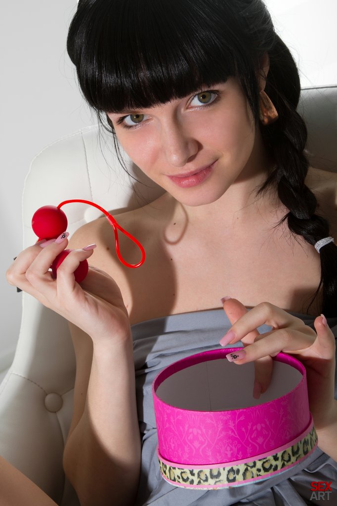 While her large, beady green eyes, cropped bangs, and braided hair implies innocence, Milania`s provocative stare and wide open poses as she masturbates with her red anal beads is oozing with raw eroticism and uninhibited sensuality.