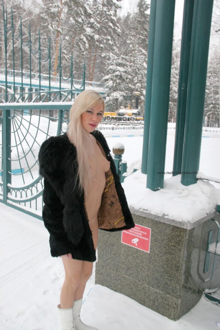 Olesia K takes off her fur coat at the entrance to the winter park