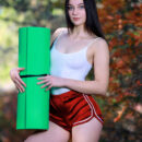 Polly Pure takes her yoga mat in the woods and removes her clothing before doing some poses which accentuates her bootylicious figure and hairless pussy.