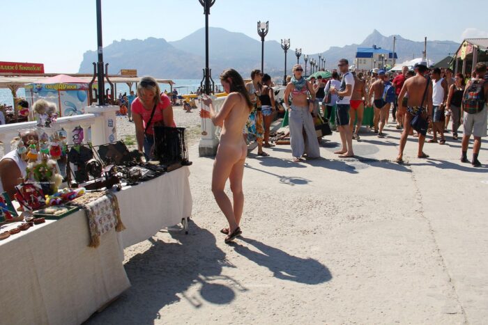 Completely naked girl Asja K on a walking street choosing souvenirs
