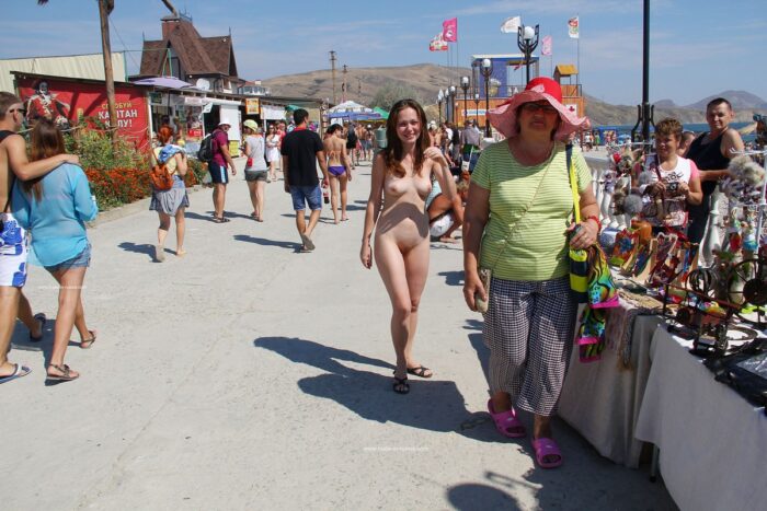 Completely naked girl Asja K on a walking street choosing souvenirs