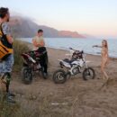 Naked russian babe Eva Gold rides a motorcycle with strangers at sandy beach