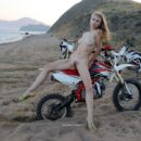 Naked russian babe Eva Gold rides a motorcycle with strangers at sandy beach