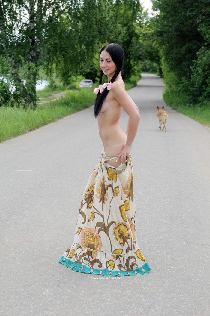 Slim brunette Veronica Snezna takes off her dress on a forest road