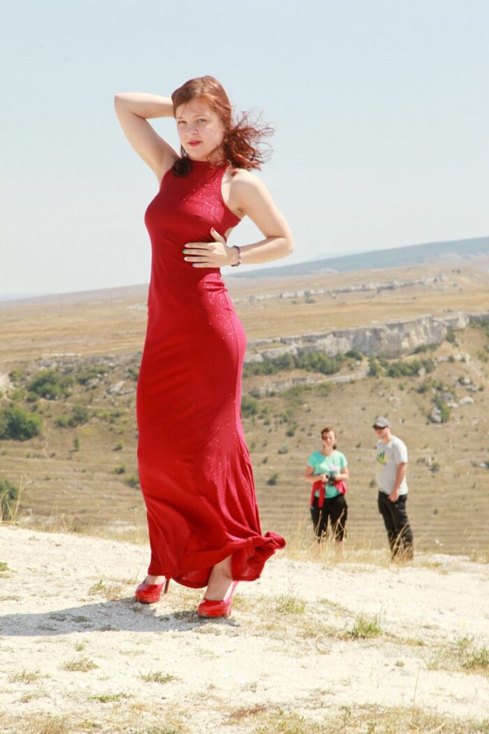 Teen Renara in red shoes on a steep rock