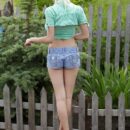 With a cute and charming smile on her pretty face, Leonie strips off her shirt and denim shorts in the garden before enjoying the refreshing cool water from th garden hose.