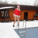 Blonde girl Rina dressed as Santa Claus on the porch