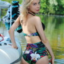 Eva Tali shows off her sexy floral high waisted bikini as she alluringly poses on the boat on the river banks.