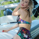 Eva Tali shows off her sexy floral high waisted bikini as she alluringly poses on the boat on the river banks.