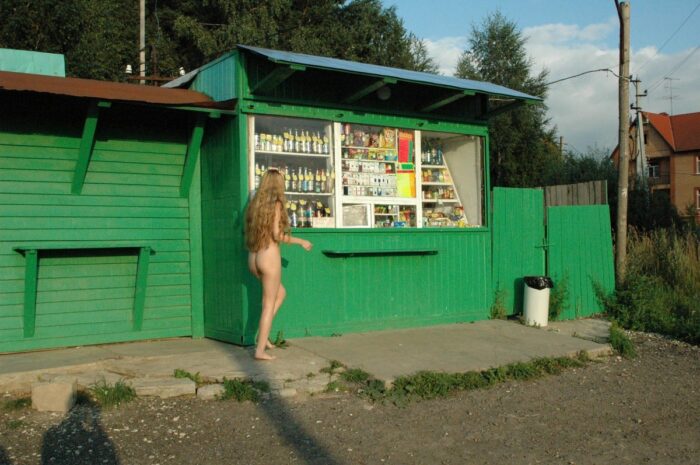 Fully naked blonde Asja poses at the kiosk