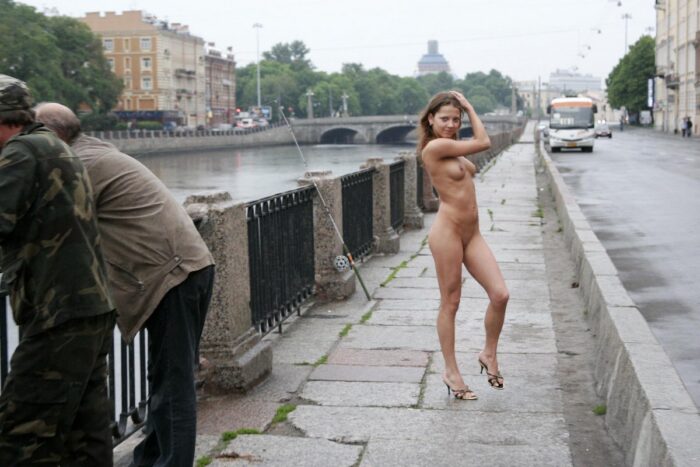 Young russian girl Janina M posing naked next to fishermen in the city