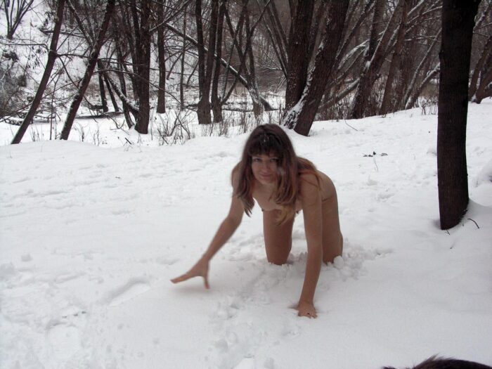 Girl Lena W removes a fur coat in the winter forest