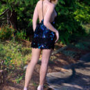 Libby is walking in the wilderness  in heels as she lifts the hem of her sexy sequined blue dress and show off her stiff knockers and shaved pinkish coochie.