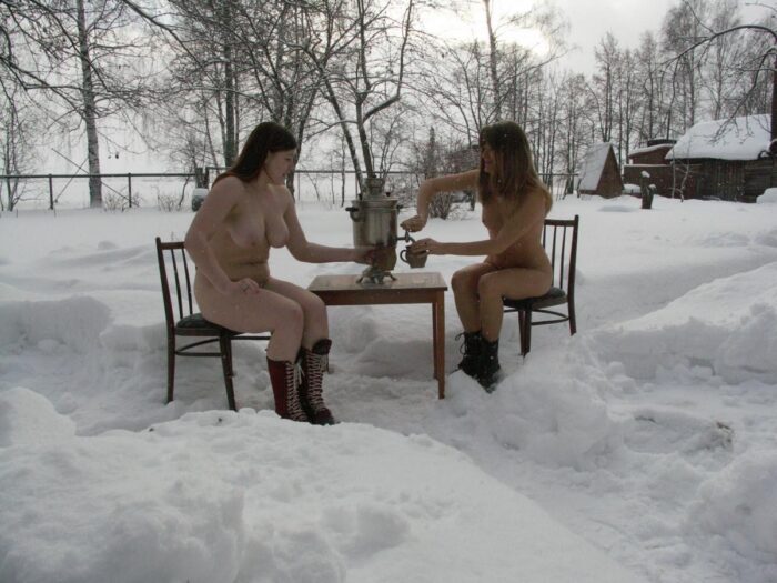 Duas meninas sem roupa tomam chá ao ar livre no inverno