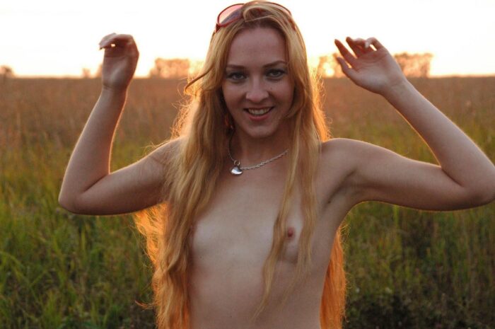 Young blond Asja with long hair and small tits in the field